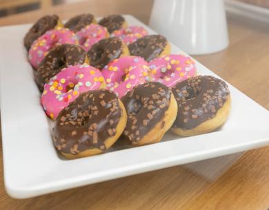 Vassoio di ciambelle con glassa rosa e cioccolato.