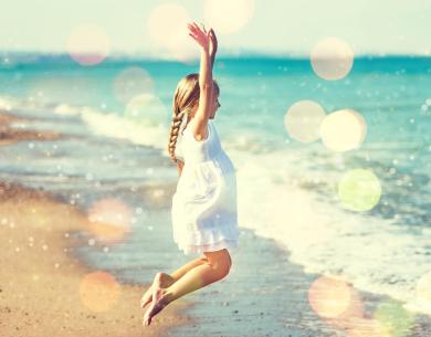Bambina felice salta sulla spiaggia, sole e mare, atmosfera magica.