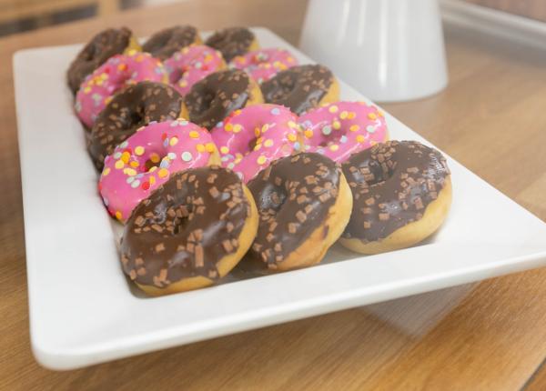 Vassoio di ciambelle con glassa rosa e cioccolato.