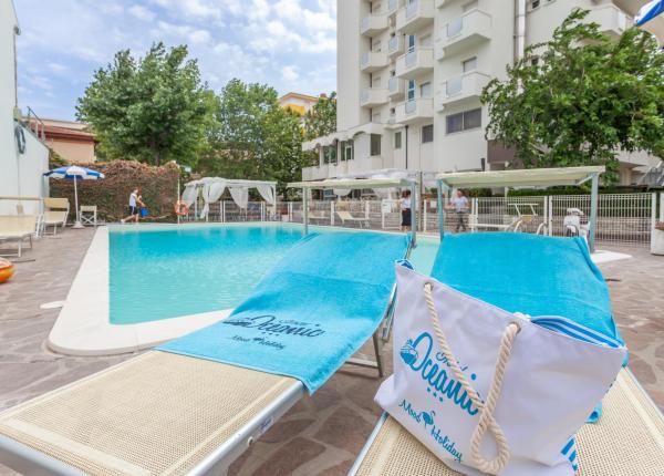 Piscina tranquilla con lettini e teli azzurri, atmosfera rilassante e vacanziera.
